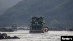 FILE - Chinese cargo ships sail on the Mekong River near the Golden Triangle at the border between Laos, Myanmar and Thailand, March 1, 2016.