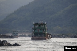 FILE - Chinese cargo ships sail on the Mekong river near the Golden Triangle at the border between Laos, Myanmar and Thailand March 1, 2016.