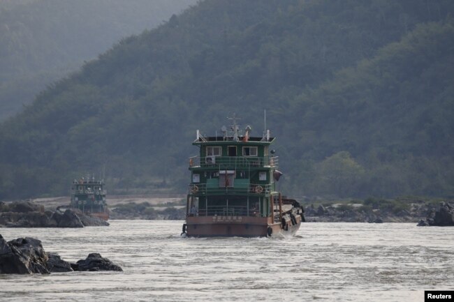 FILE - Chinese cargo ships sail on the Mekong river near the Golden Triangle at the border between Laos, Myanmar and Thailand March 1, 2016.