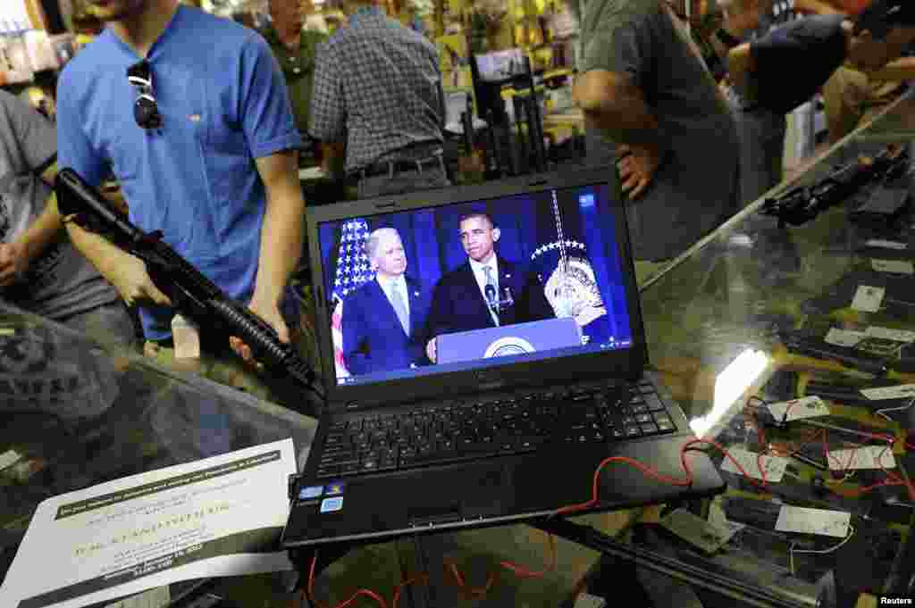 Gun shop customers shop for weapons at the Bullet Hole gun shop in Sarasota, Florida, as they listen to live streaming video of an announcement about gun control by U.S. President Barack Obama. Obama proposed a new assault weapons ban and mandatory background checks for all gun buyers.