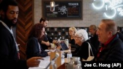 In this February 19, 2019 photo, a group of seniors from Laguna Woods Village consult with sales associates at Bud and Bloom cannabis dispensary in Santa Ana, California.