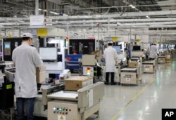 FILE - Employees work at a mobile phone production line at a Huawei factory in Shenzhen city, in southern China's Guangdong province, Jan. 15, 2019.