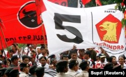 Polisi mengawal pendukung Partai Demokrasi Indonesia Perjuangan (PDI-P) dan Partai Gerakan Indonesia Raya (GERINDRA) di Komisi Pemilihan Umum di Jakarta, 16 Mei 2009. (Foto: REUTERS/Supri)