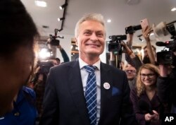Economist Gitanas Nauseda, a presidential candidate, celebrates winning the first round of Lithuania's presidential election in office in Vilnius, Lithuania, early Monday, May 13, 2019.