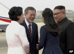 South Korean President Moon Jae-in, second from left, and his wife Kim Jung-sook, left, are welcomed by North Korean leader Kim Jong Un and his wife Ri Sol Ju upon their arrival in Pyongyang, North Korea, Sept. 18, 2018.