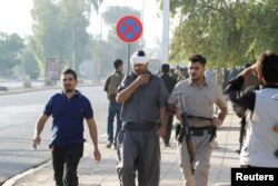 An injured Kurdish man walks at a site of an attack by Islamic State militants in Kirkuk, Iraq, Oct. 21, 2016.