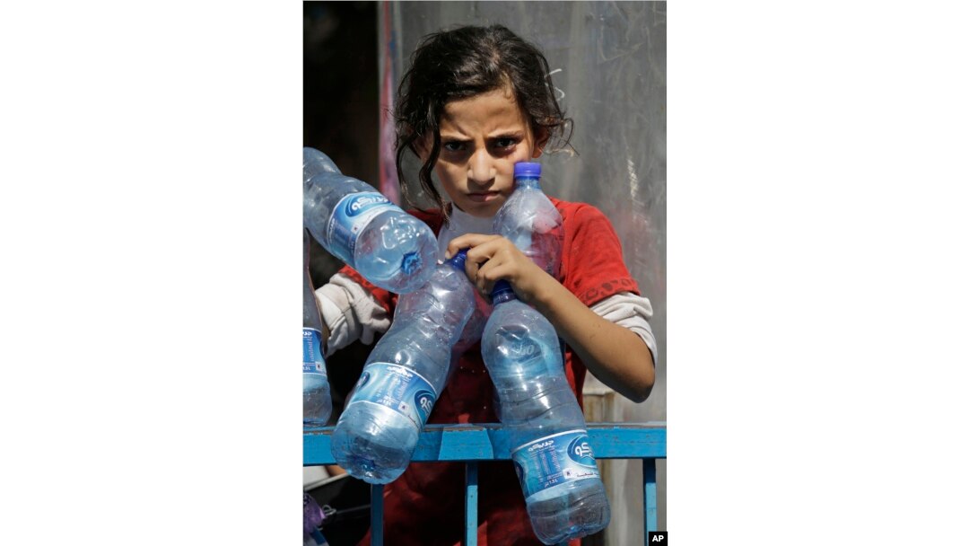 Palestinian Naama Al Attar, 13, waits to collect water at a U.N. school in Gaza City on Aug. 8, 2014.