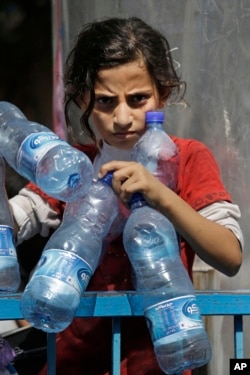 Palestinian Naama Al Attar, 13, waits to collect water at a U.N. school in Gaza City on Aug. 8, 2014.