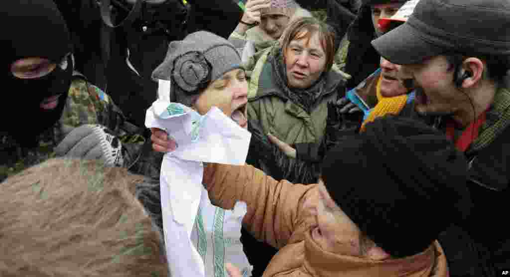 Pro-European Union activists and anti-protesters argue at a barricade of a tent camp, Kyiv, Ukraine, Jan. 18, 2014. 