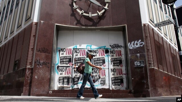 Una mujer pasa frente a un banco cerrado en Río Piedras, Puerto Rico.