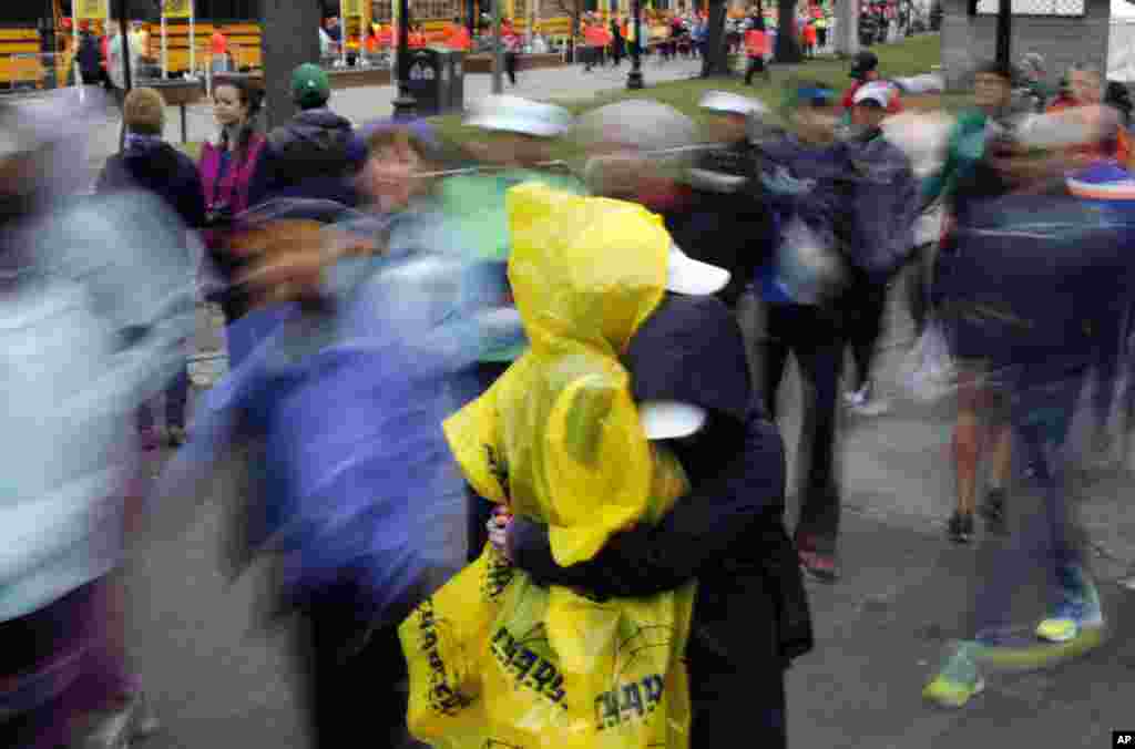 Pelari Boston Marathon Tenee Ramsdell (kiri) mendapat pelukan dari Evangline Gersish, keduanya dari San Diego, sebelum naik bus menuju garis start di Hopkinton (20/4). ​(AP/Robert F. Bukaty)