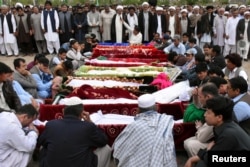 Relatives and others gather at a funeral for the victims of a blast at vegetable market, at a cemetery in Quetta, Pakistan, April 12, 2019.