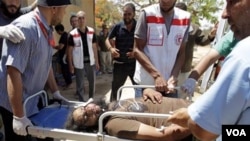 Petugas medis mengangkut seorang anggota pasukan pemberontak Libya yang terluka di pinggiran kota Misrata.