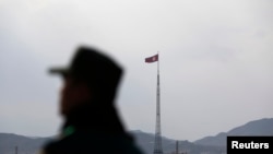 资料照：在板门店停战村附近拍摄的这张照片中，朝鲜国旗在朝鲜宣传村纪中洞的一座塔顶飘扬。（路透社）