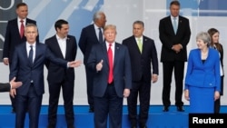 川普总统在北约成员国领导人合影时打出手势。2018年7月11日。