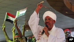 Supporters wave Sudanese flags as Sudanese President Omar al-Bashir addresses supporters during a rally at the ruling National Congress Party headquarters in Khartoum, Sudan, April 18, 2012.