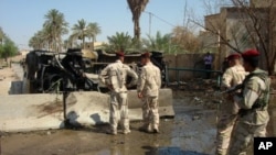 Iraqi soldiers inspect the site of a bomb attack in Diwaniya, 150 km (95 miles) south of Baghdad, June 21, 2011