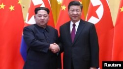 El líder norcoreano, Kim Jong Un, y el presidente chino, Xi Jinping, posan en esta foto de su visita no oficial a Pekín.