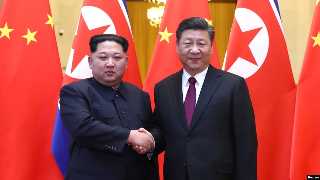 Lãnh tụ Triều Tiên Kim Jong Un và Chủ tịch Trung Quốc Tập Cận Bình bắt tay trong Đại lễ đường Nhân dân ở Bắc Kinh, Trung Quốc, trong bức hình được công bố vào ngày 28 tháng 3, 2018.