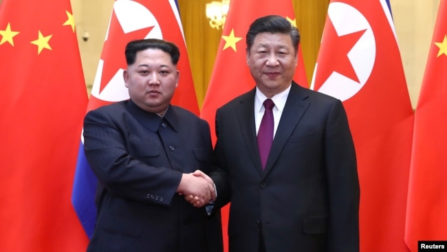 中共中央总书记、国家主席习近平和朝鲜劳动党委员长、国务委员会委员长金正恩在北京人民大会堂握手（2018年3月28日发布的照片）