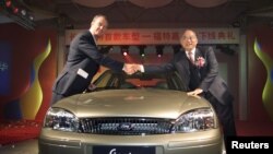 资料照：中国兵器工业集团董事长尹家绪（右）在时任长安汽车高管时与福特公司付执行官瑟斯菲尔德握手。
