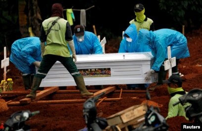 Para petugas menggunakan baju pelindung memakamkan korban virus corona (COVID-19) di sebuah pemakaman yang disediakan pemerintah, di Jakarta, 3 April 2020. (Foto: Reuters)