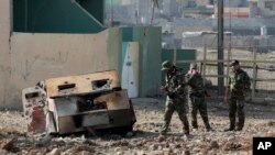 Soldados del Ejército iraquí inspeccionan un coche bomba que estalló en un barrio recientemente liberado de militantes islámicos en el lado oriental de Mosul, Irak, este domingo 8 de enero de 2017.