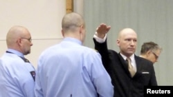 Mass killer Anders Behring Breivik raises his arm in a Nazi salute as he enters the court room in Skien prison, Norway, March 15, 2016.