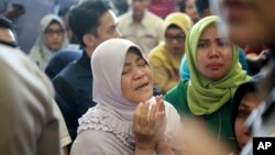 A relative of passengers prays as she and others wait for news on a Lion Air plane that crashed off Java Island at Depati Amir Airport in Pangkal Pinang, Indonesia Monday, Oct. 29, 2018. 