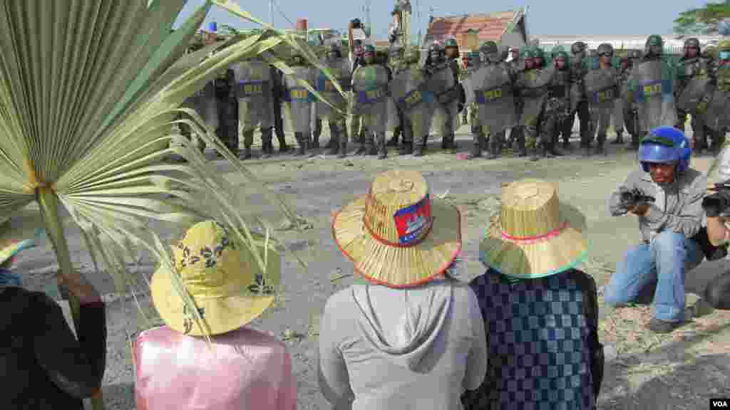 Striking garment workers are seen in front of police in Phnom Penh, Jan. 2, 2014. (VOA Khmer)