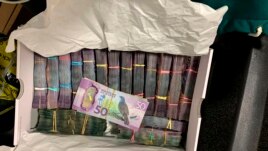 In this undated photo supplied by the New Zealand police, a box containing a large amounts of cash is seen after being discovered during a police raid as part of Operation Trojan. Authorities in Australia and New Zealand Tuesday, June 8, 2021