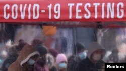 Moun ki mete yo an liyn pou yo teste pou KOVID-19 nan Times Square, anba lavil New York, lendi 20 desanm 2021 an, nan moman varyan omikwonn nan kontiye gaye nan dives eta ameriken. (Foto Dosye: REUTERS/Andrew Kelly).