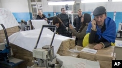 Members of regional election commission inspect voters ballots in a printing house in Mariupol, a major port and steel city in Ukraine's east, Oct. 25, 2015.