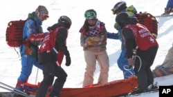 United States' Arielle Gold is assisted after injuring her hand after falling during the women's snowboard halfpipe warm-up, Feb. 12, 2014, in Krasnaya Polyana, Russia.