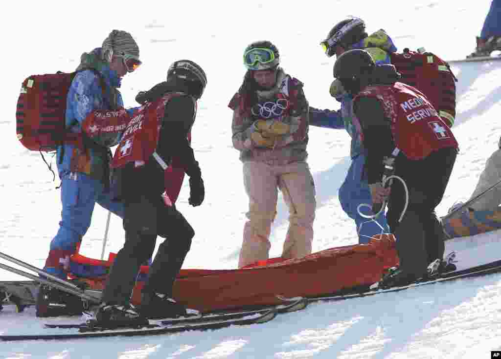 Arielle Gold dari AS dibantu keluar setelah tangannya cedera saat melakukan pemanasan sebelum nomor halfpipe, Krasnaya Polyana, Rusia, 12 Februari 2014.