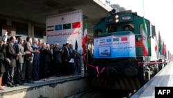 Les autorités iraniennes applaudissent sur la plate-forme à l'arrivée du premier train reliant la Chine et l'Iran arrive à la gare de Téhéran le 15 février 2016.