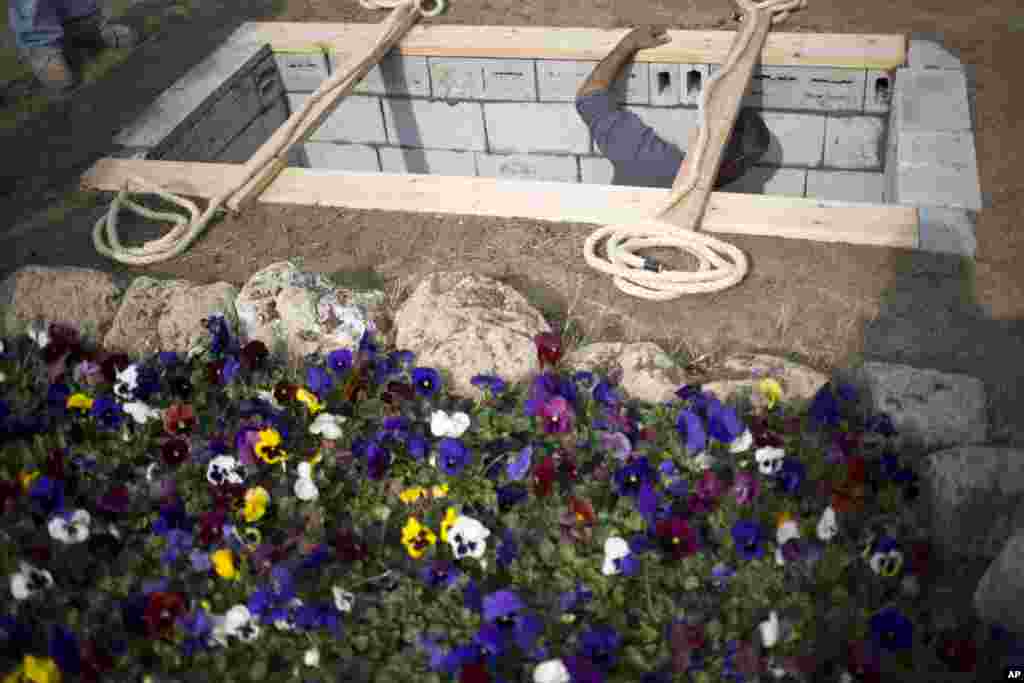A worker prepares the grave for Israeli Prime Minister Ariel Sharon who will be buried next to his wife at his ranch, Havat Shikmim, in the northern Negev Desert, southern Israel, January 12, 2014. 