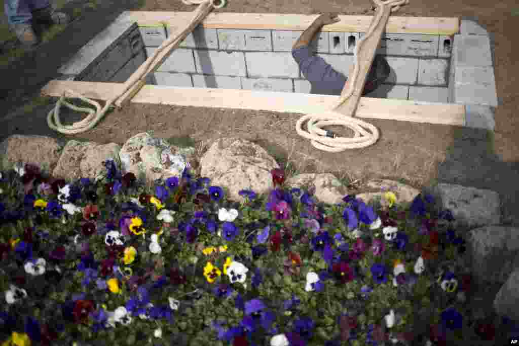 A worker prepares the grave for former Prime Minister Ariel Sharon at his ranch, Havat Shikmim, in the northern Negev Desert, southern Israel, Jan. 12, 2014.&nbsp;