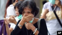 A relative of a victim of AirAsia Flight 8501 waits for the handover of the body to the family at a police hospital in Surabaya, East Java, Indonesia, Monday, Jan. 5, 2015.