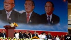 From left to right seated in front row, Cambodian National Assembly President Heng Samrin, Senate President Chea Sim, Prime Minister Hun Sen, and his wife Bun Rany attend an event by the ruling Cambodian People's Party marking the 35th anniversary of the 1979 downfall of the Khmer Rouge regime at Koh Pich, in Phnom Penh, Cambodia, Tuesday, Jan. 7, 2014.