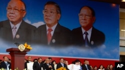 From left to right seated in front row, Cambodian National Assembly President Heng Samrin, Senate President Chea Sim, Prime Minister Hun Sen, and his wife Bun Rany attend an event by the ruling Cambodian People's Party marking the 35th anniversary of the 1979 downfall of the Khmer Rouge regime at Koh Pich, in Phnom Penh, Cambodia, Tuesday, Jan. 7, 2014. 