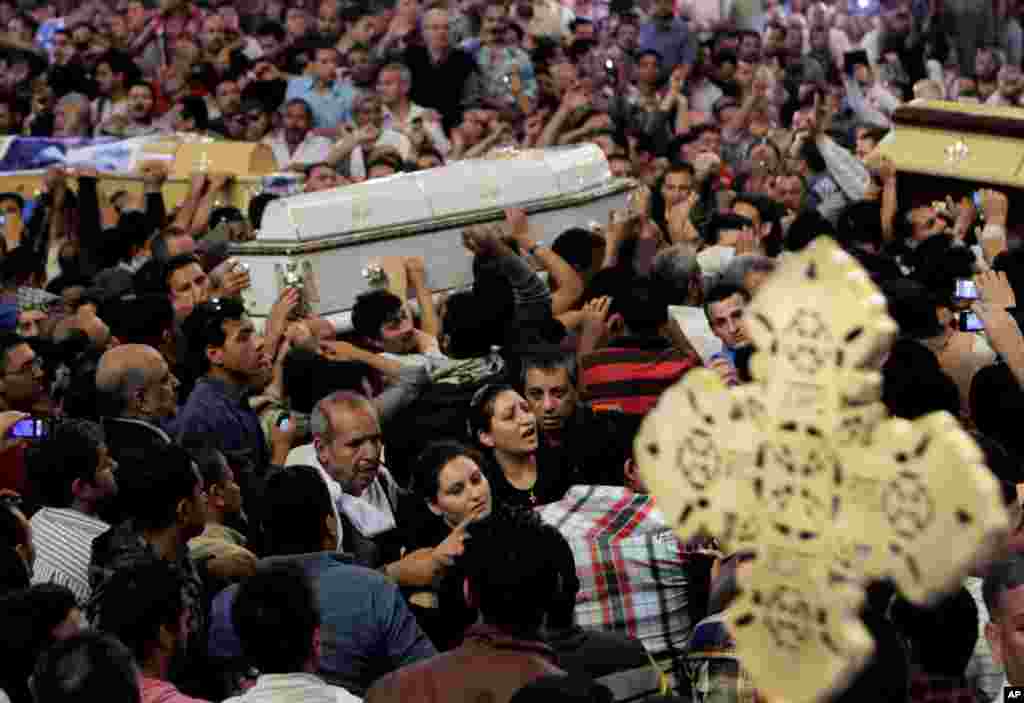 Egyptian Christians carry four coffins during a funeral service, at the Saint Mark Coptic cathedral in Cairo, Egypt, April 7, 2013. 