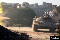 FILE - A Free Syrian Army tank fires in Ramousah area, southwest of Aleppo, Syria, Aug. 2, 2016.