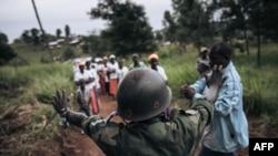 file: A militiaman of the armed group URDPC/CODECO from the Lendu community makes a stop sign at a religious procession of the CODECO sect in the village of Masumbuko, Ituri Province, northeastern Democratic Republic of Congo on September 18, 2020.