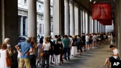 FILE - People line up to enter the Uffizi Gallery in Florence, Italy, Aug. 1, 2017.