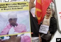 FILE - Indonesian workers shout slogans during a protest against the alleged abuse of an Indonesian maid in Saudi Arabia, outside the Parliament in Jakarta, Indonesia, Nov. 23, 2010.