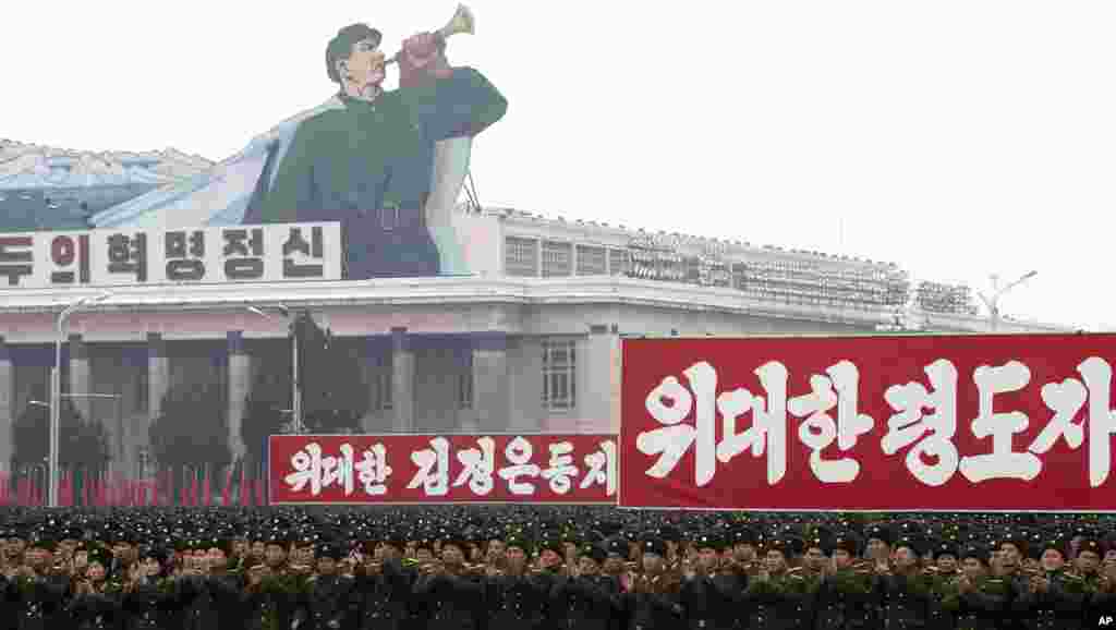 North Korean soldiers applaud near signs from left which reads "revolutionary spirit," "Great leader comrade Kim Jong Un" and "Great leader" during a mass rally in Kim Il Sung Square in Pyongyang, North Korea, December 14, 2012.