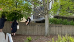 Students wearing graduation clothing pose for photos at Carnegie Mellon University.