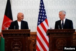 FILE - Afghanistan's president Ashraf Ghani, left, and U.S. Defense Secretary James Mattis, right, attend a news conference in Kabul, Afghanistan, Sept. 27, 2017.