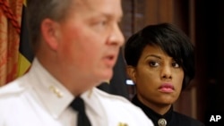 After announcing the firing of Police Commissioner Anthony Batts, Baltimore Mayor Stephanie Rawlings-Blake listens as Interim Commissioner Kevin Davis talks to reporters in Baltimore, July 8, 2015.